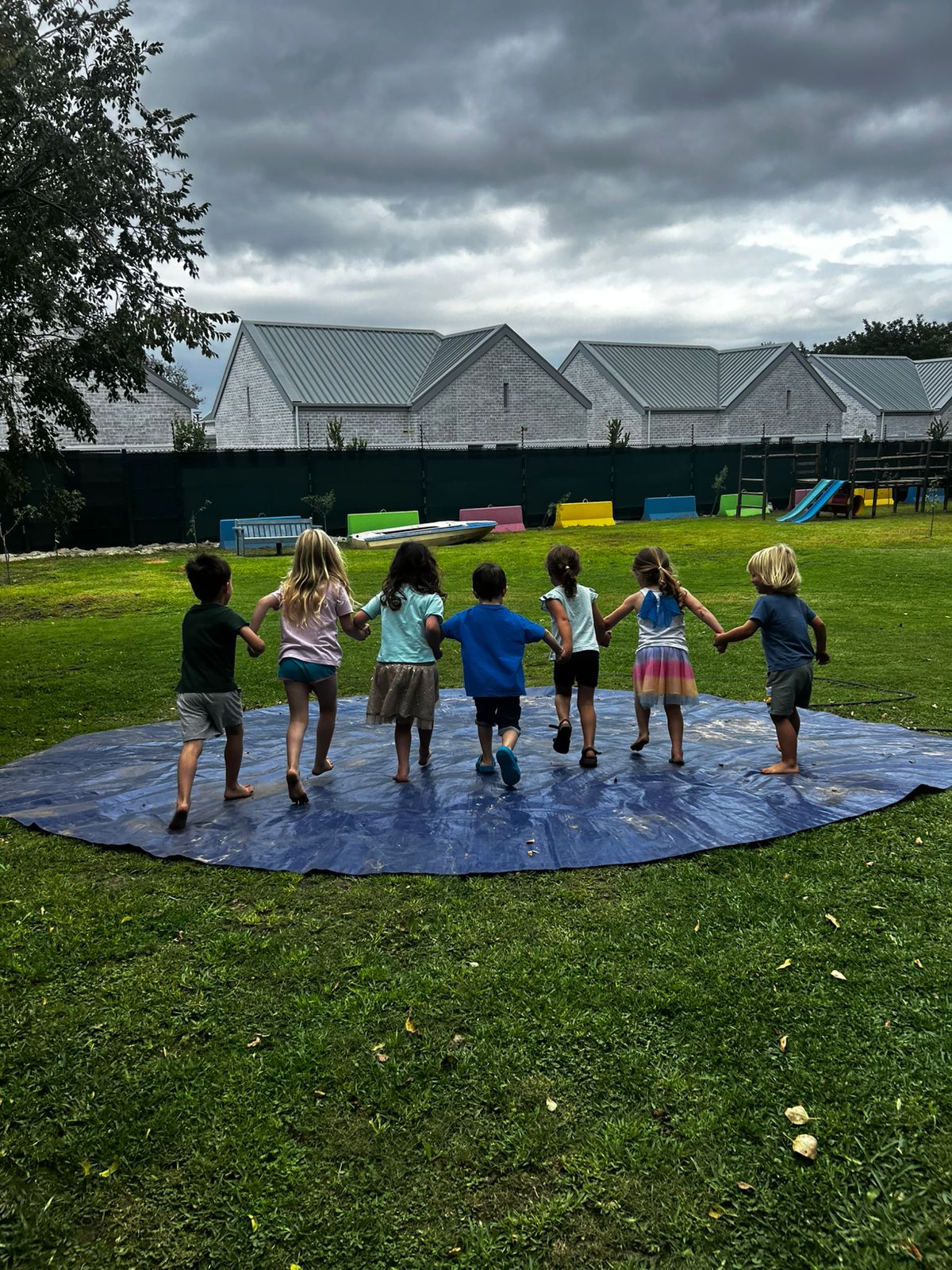 Children holding hands together on the lawn