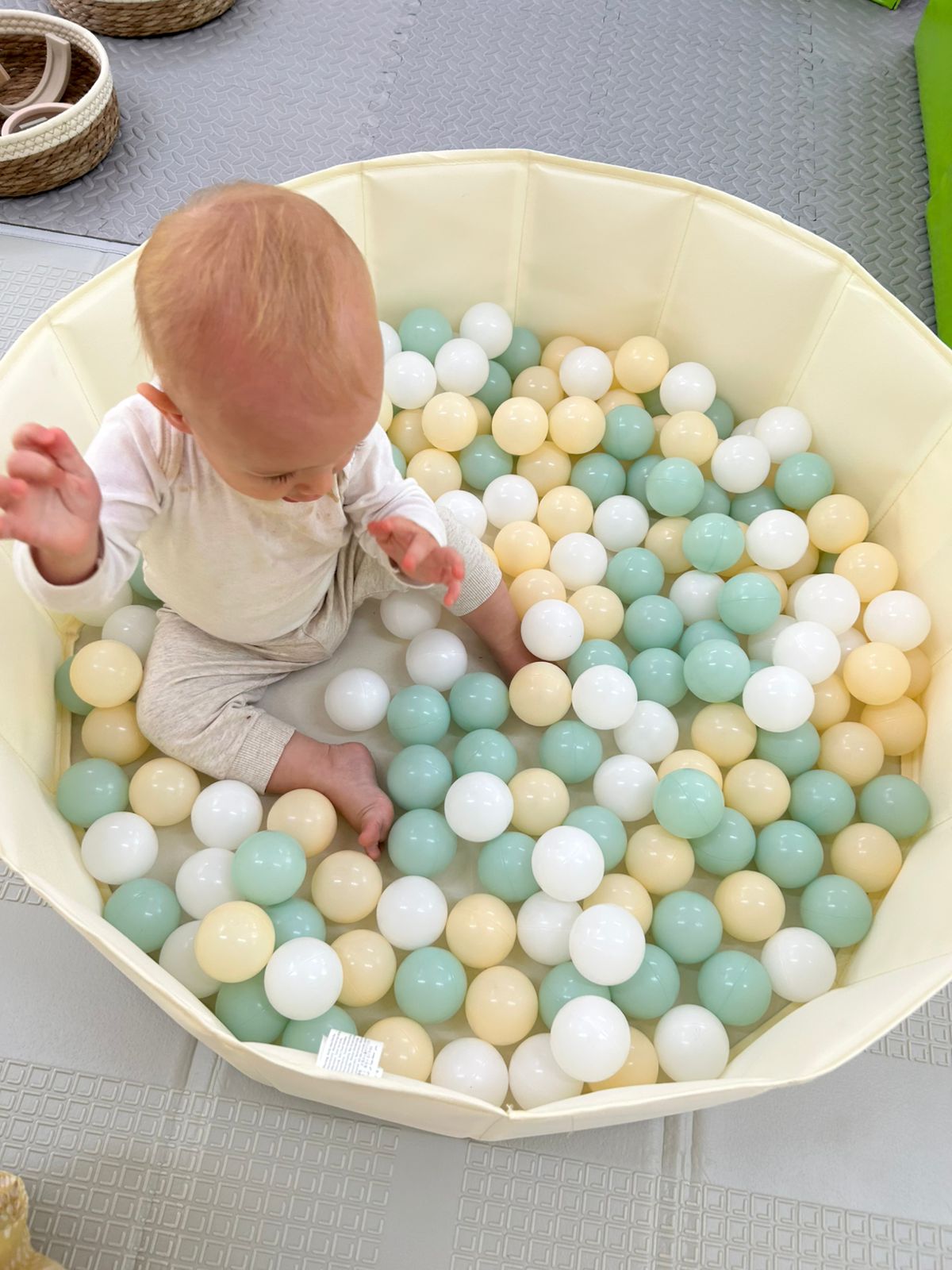 Baby exploring a pastel ball pit
