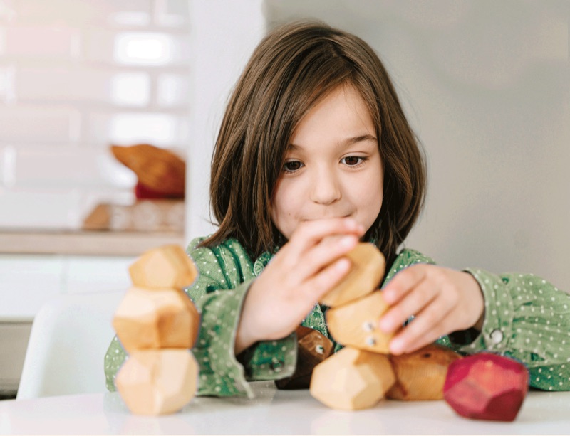 Child stacking wooden blocks in the classroom